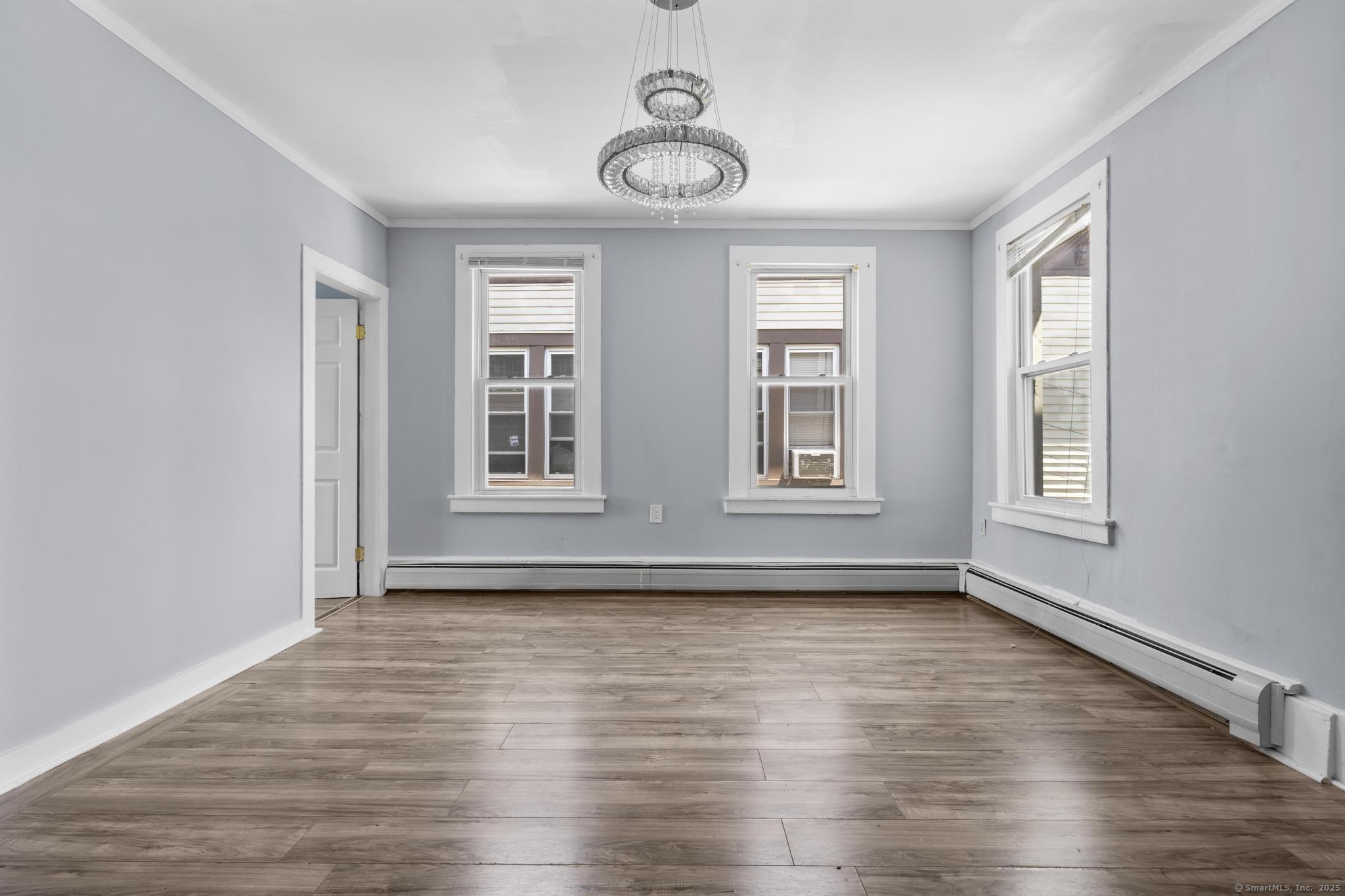 387 Nichols Street, Unit 2 Bridgeport, CT 06608 - Photo 5 of 28 a view of an empty room with wooden floor and a window