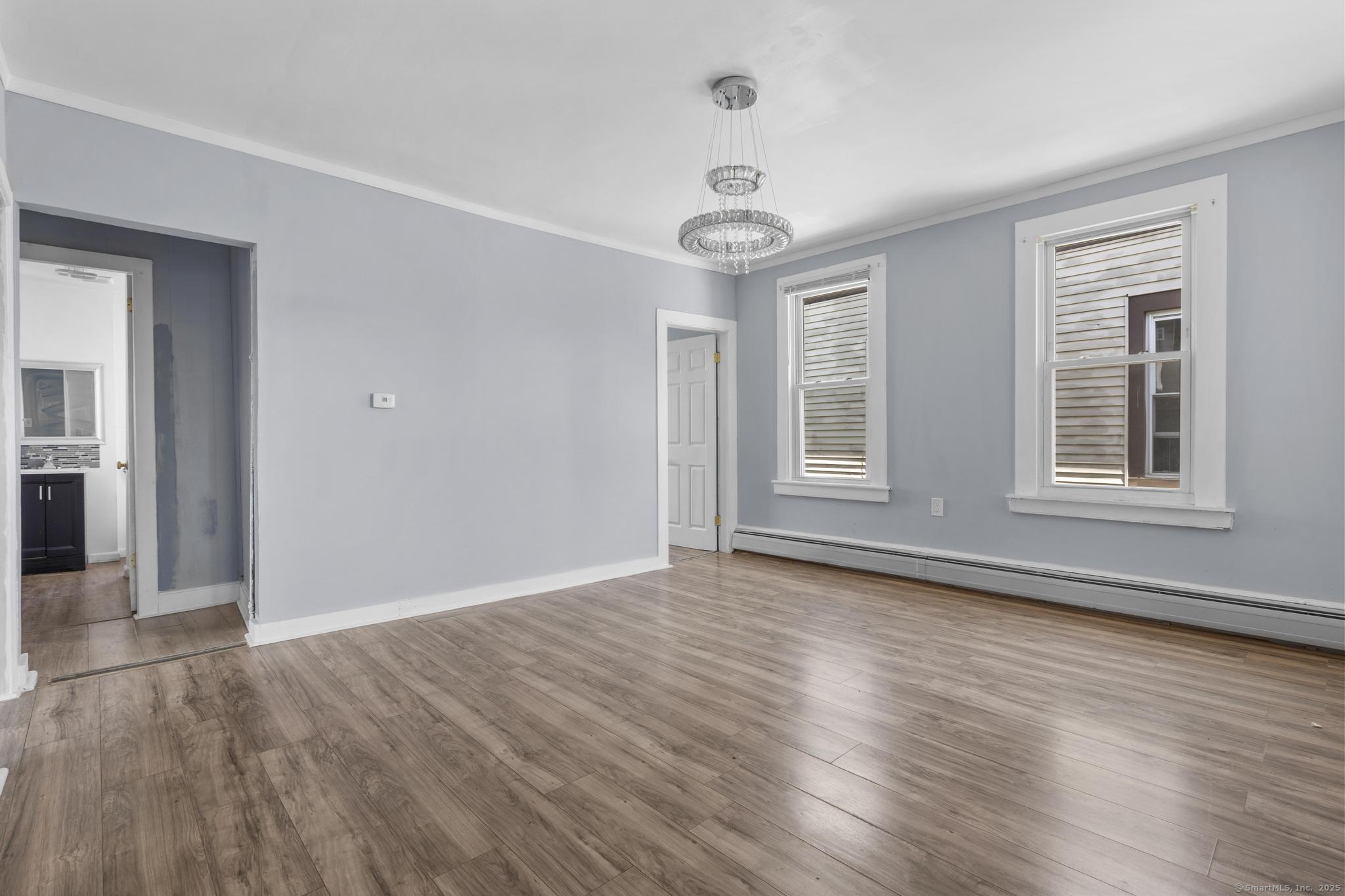 387 Nichols Street, Unit 2 Bridgeport, CT 06608 - Photo 6 of 28 a view of an empty room with wooden floor and a window