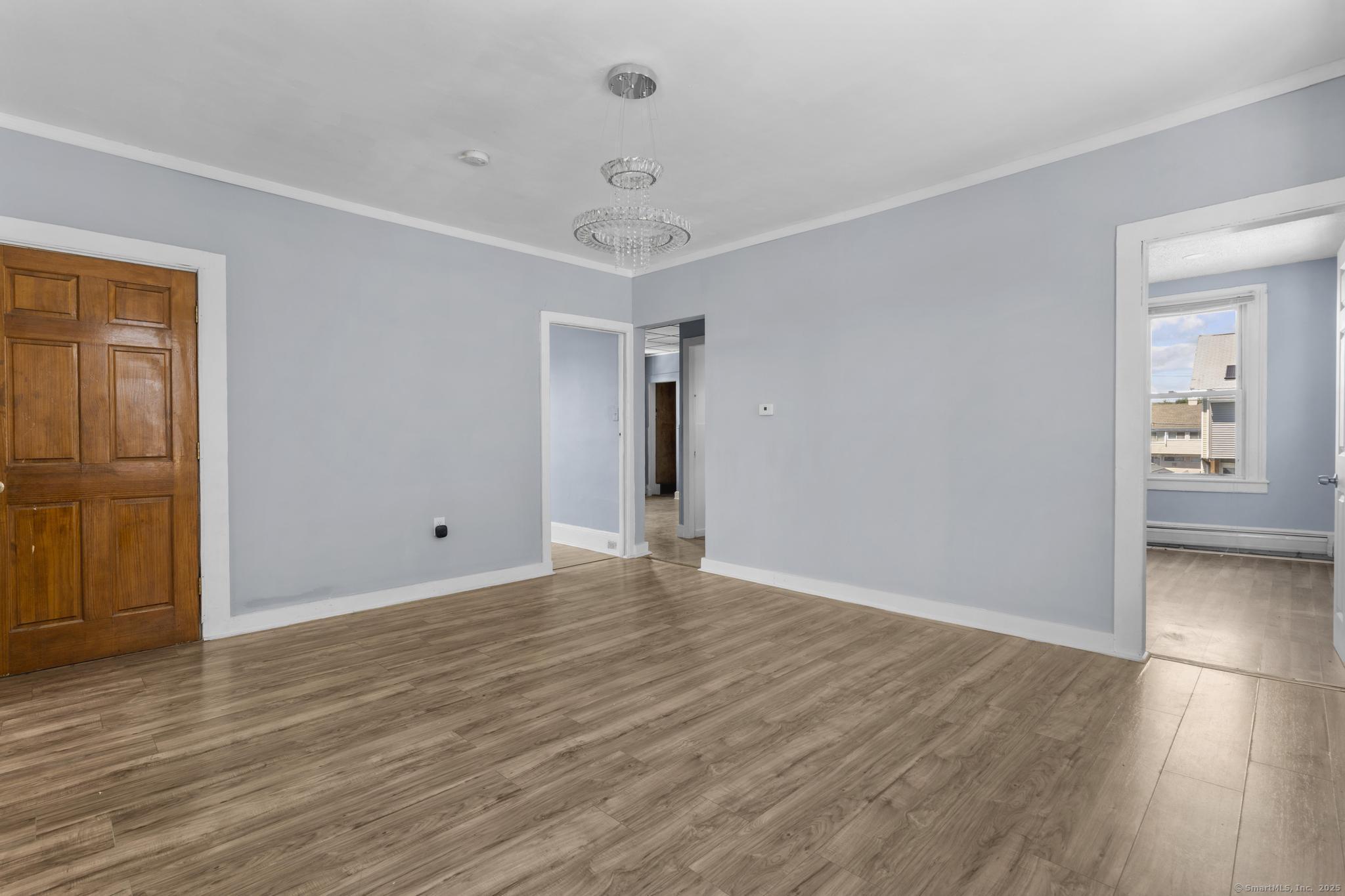 387 Nichols Street, Unit 2 Bridgeport, CT 06608 - Photo 7 of 28 a view of an empty room with wooden floor and a window