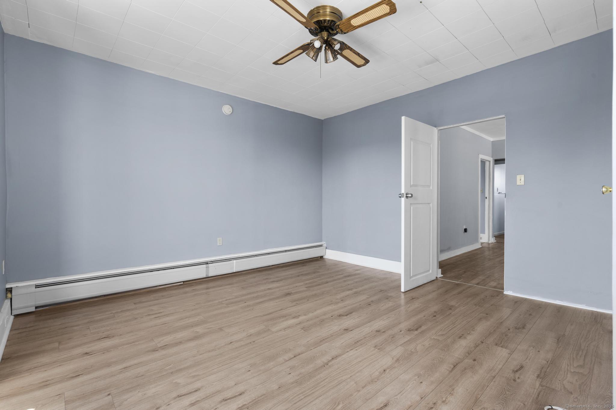 387 Nichols Street, Unit 2 Bridgeport, CT 06608 - Photo 10 of 28 an empty room with wooden floor and windows