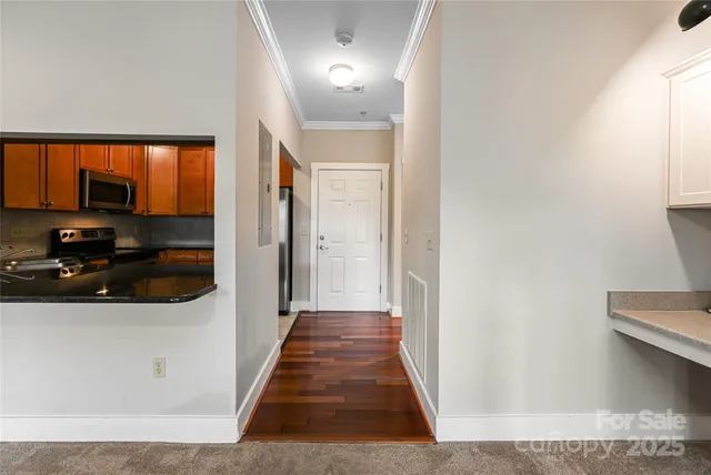 a view of a hallway view with wooden floor and electronic appliances