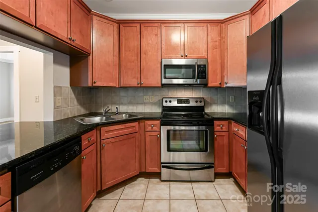 a kitchen with stainless steel appliances granite countertop a refrigerator stove and sink