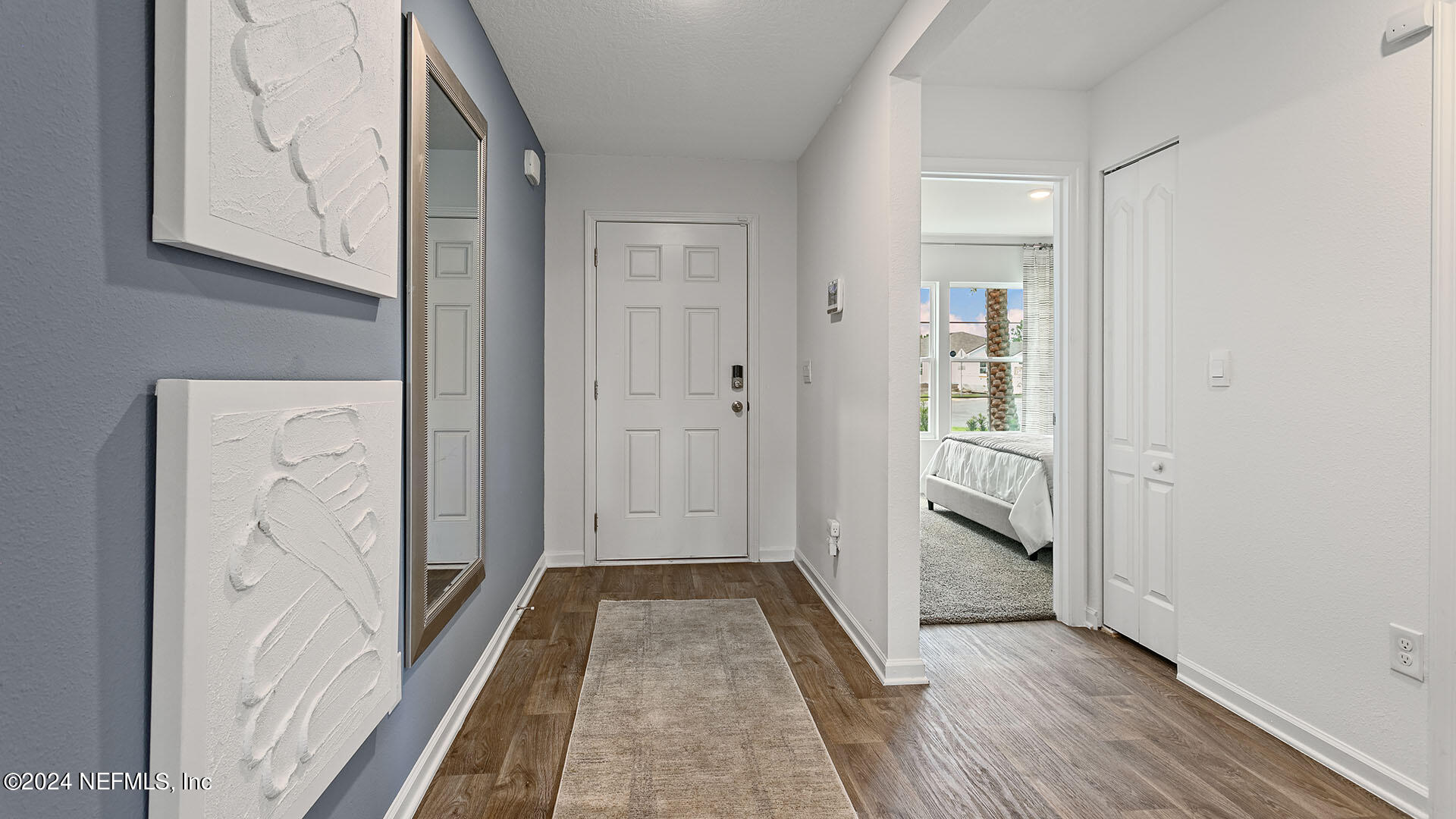 123 Hulett Wds Road Palm Coast, FL 32137 - Photo 3 of 33 a view of a hallway with wooden floor and closet
