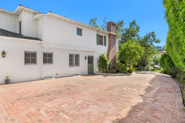 a view of a house with a big yard and potted plants