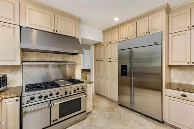 a kitchen with stainless steel appliances a stove a sink and a microwave