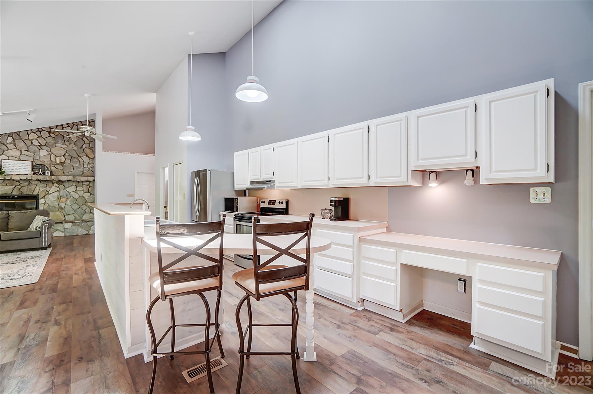 1205 Molokai Drive Tega Cay, SC 29708 - Photo 13 of 32 a kitchen with stainless steel appliances white cabinets and wooden floor