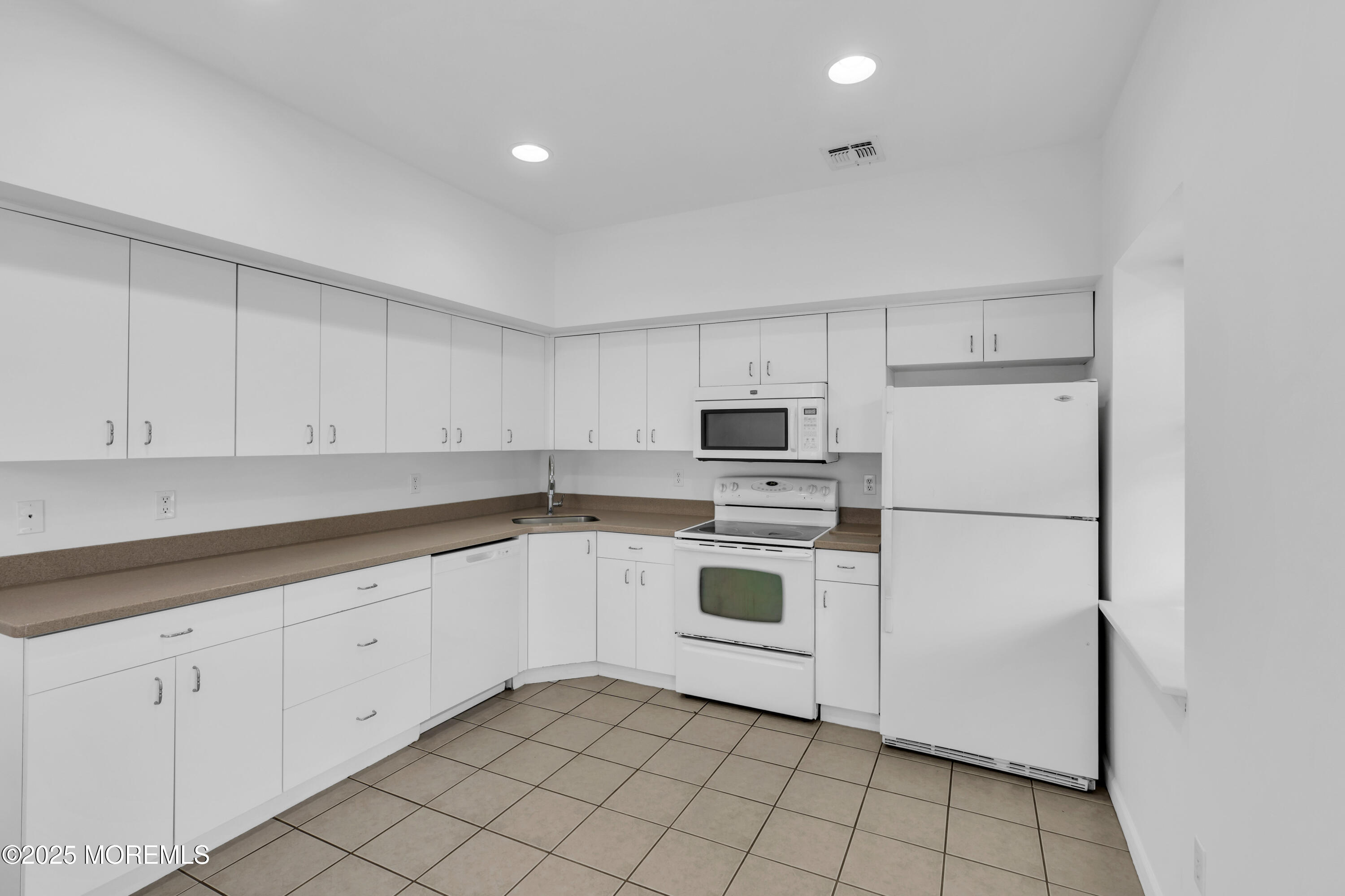 101 Main Street Farmingdale, NJ 07727 - Photo 7 of 24 a kitchen with white cabinets and white appliances