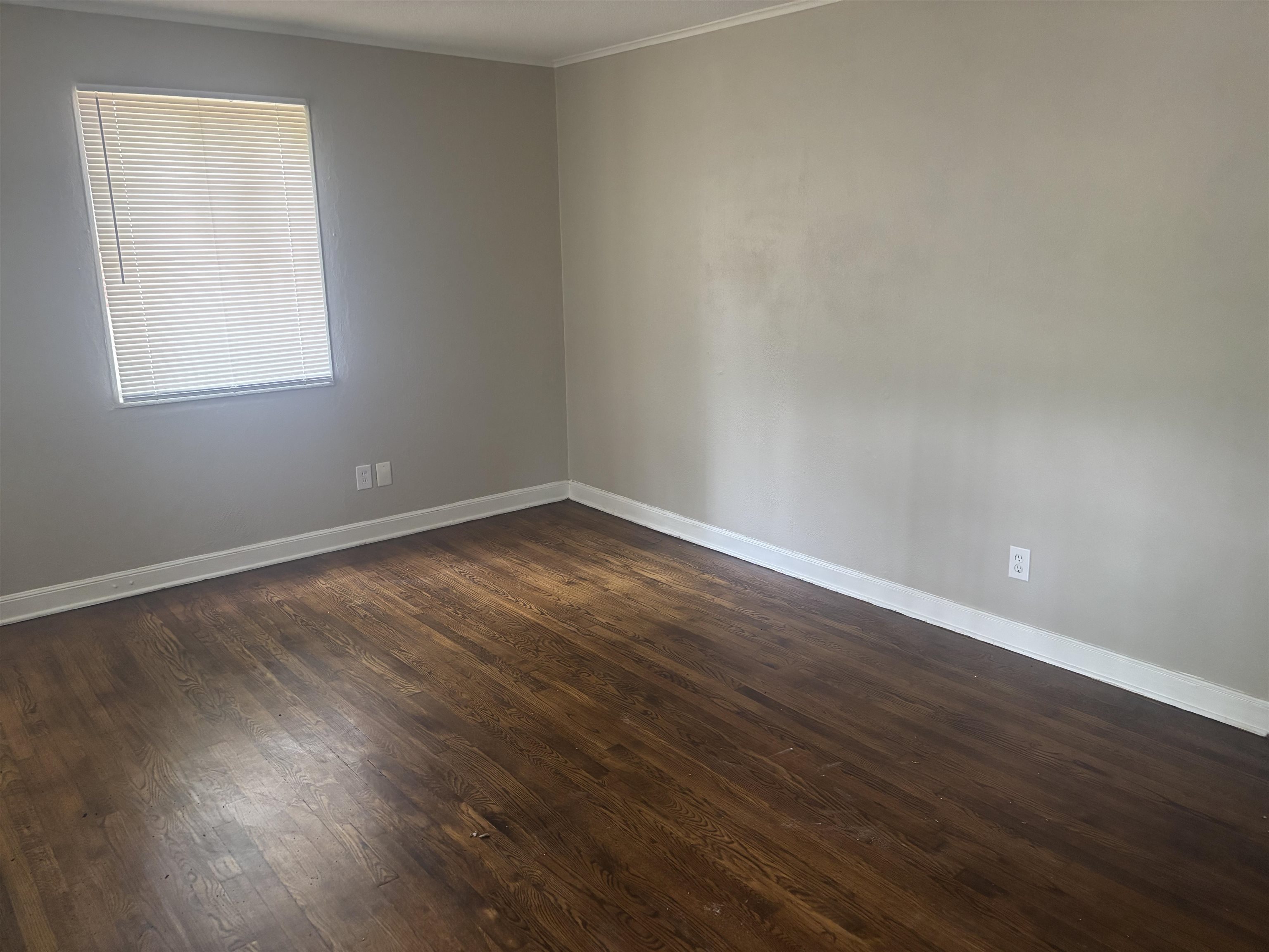 2106 Brookline Road Memphis, TN 38128 - Photo 4 of 10 Empty room with crown molding, dark wood-style floors, and baseboards