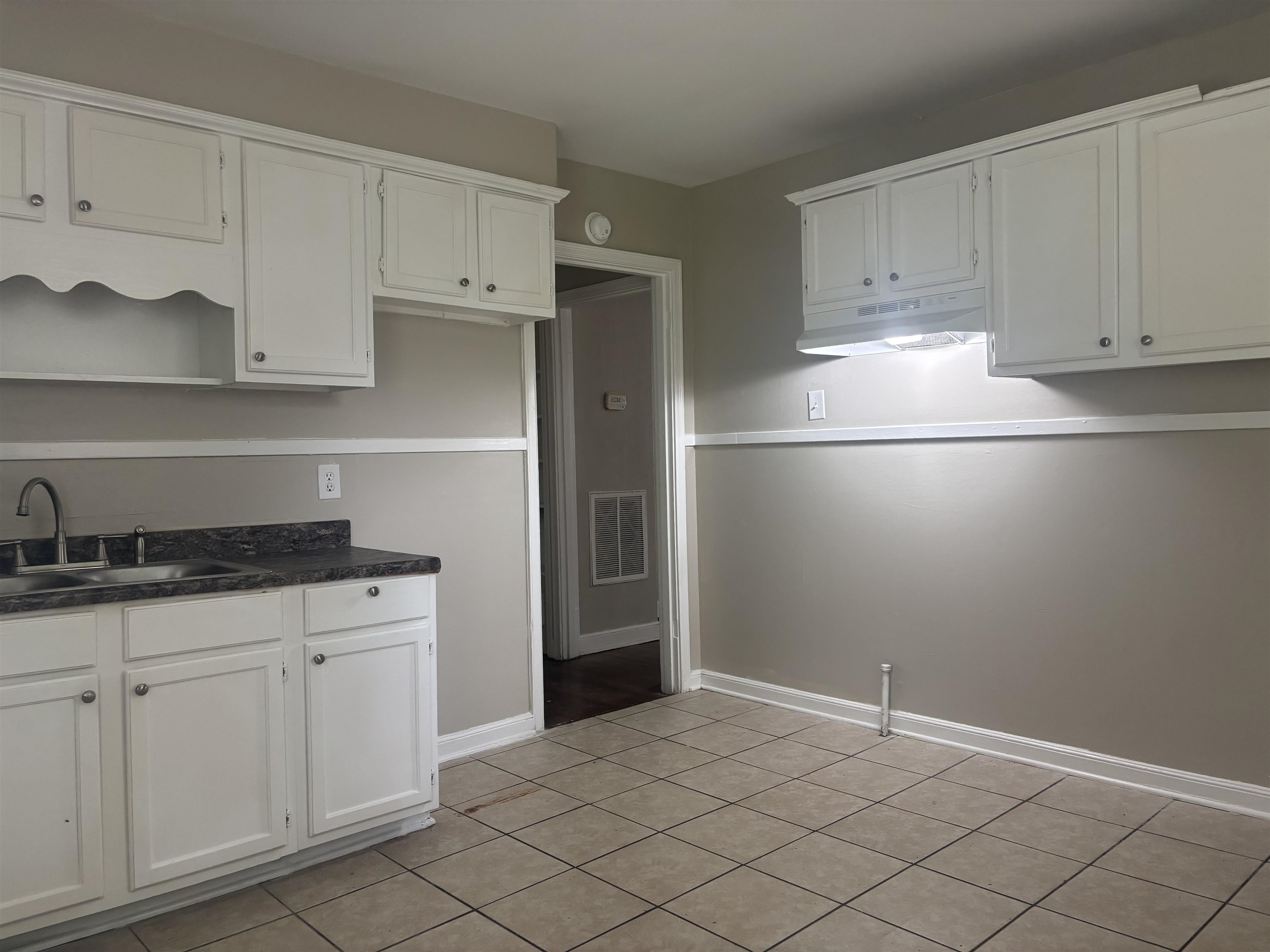 2106 Brookline Road Memphis, TN 38128 - Photo 5 of 10 Kitchen with under cabinet range hood, open shelves, white cabinetry, a sink, and baseboards