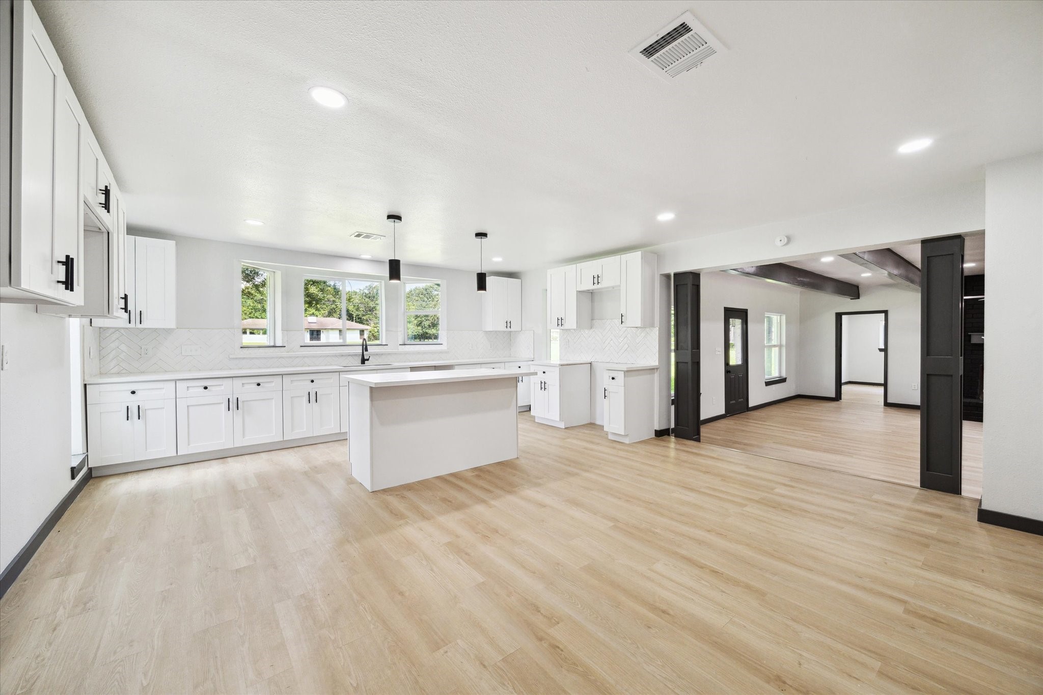 13812 Goodyear Road Dayton, TX 77535 - Photo 2 of 14 a large white kitchen with kitchen island a sink a stove and a refrigerator