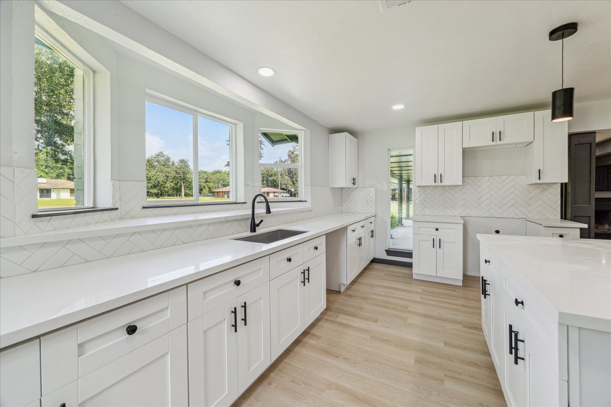 13812 Goodyear Road Dayton, TX 77535 - Photo 3 of 14 a large white kitchen with granite countertop a large window and white stainless steel appliances