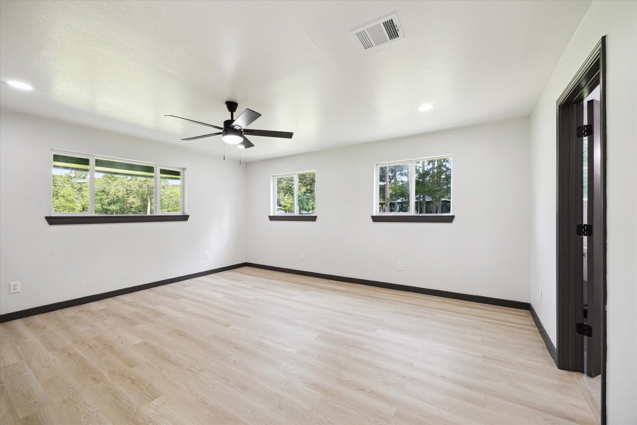 13812 Goodyear Road Dayton, TX 77535 - Photo 5 of 14 wooden floor in an empty room with a window