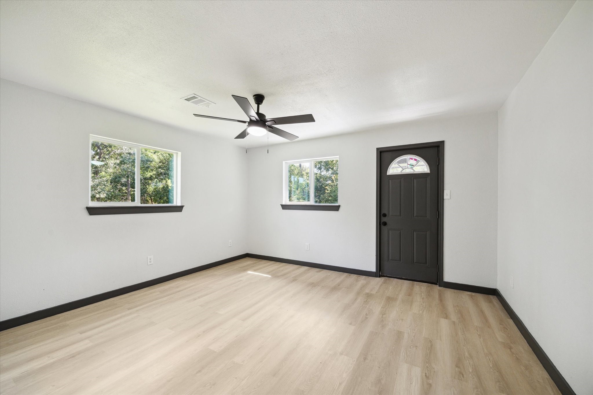 13812 Goodyear Road Dayton, TX 77535 - Photo 10 of 14 a view of a big room with wooden floor and windows