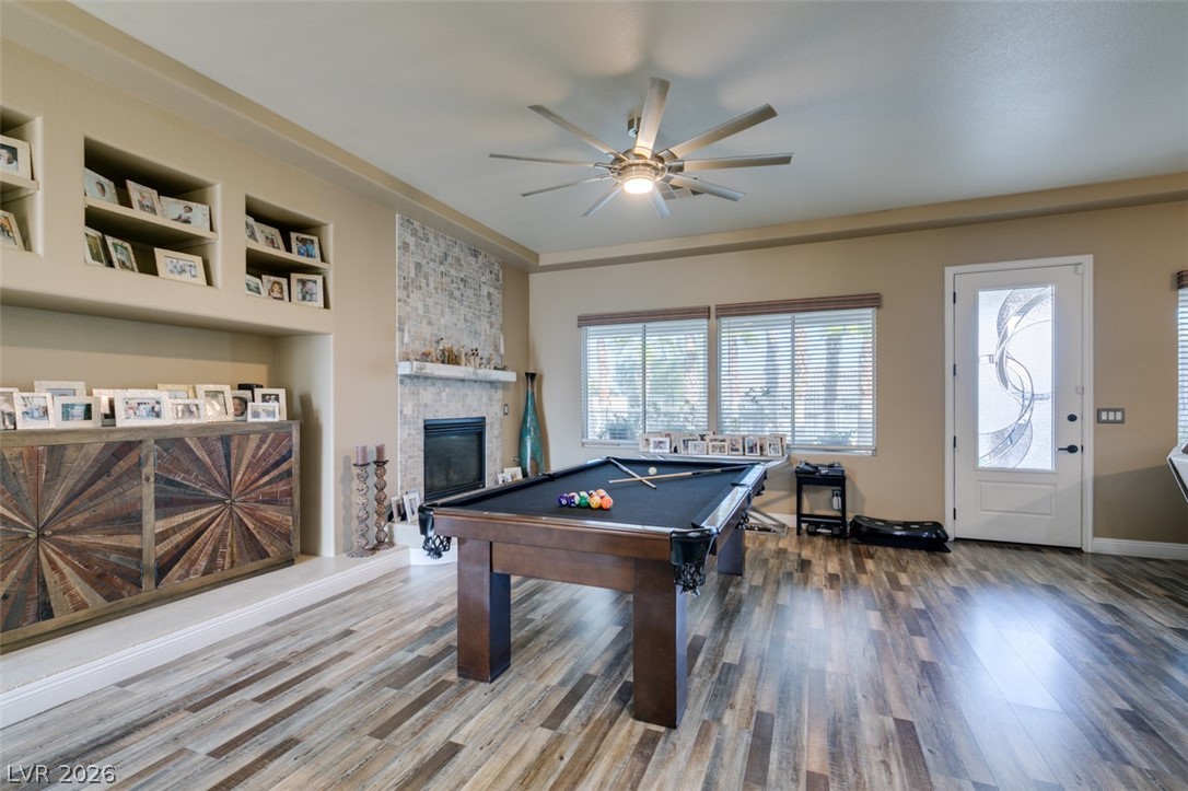 7524 Midnight Rambler Street Las Vegas, NV 89149 - Photo 8 of 51 A refined gathering space features a statement fireplace and elegant wood flooring, perfect for recreation.