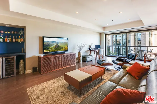 a living room with furniture a flat screen tv and a floor to ceiling window