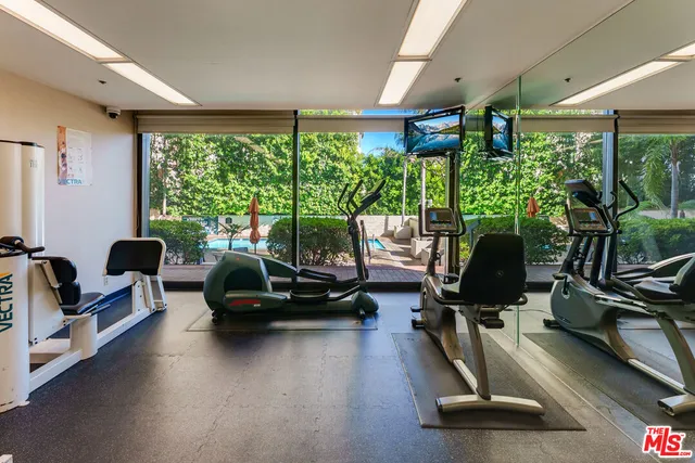 a living room with furniture gym equipment and a large window