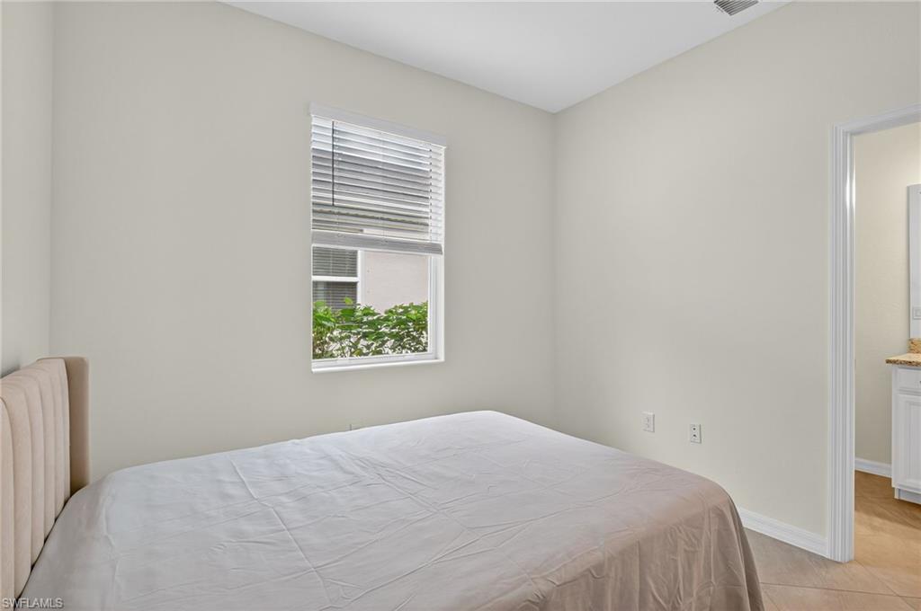 2126 Hamlin Street Naples, FL 34120 - Photo 20 of 38 a bedroom with a bed and a window