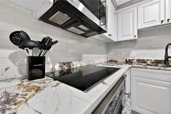a kitchen with stainless steel appliances granite countertop a sink a stove and cabinets