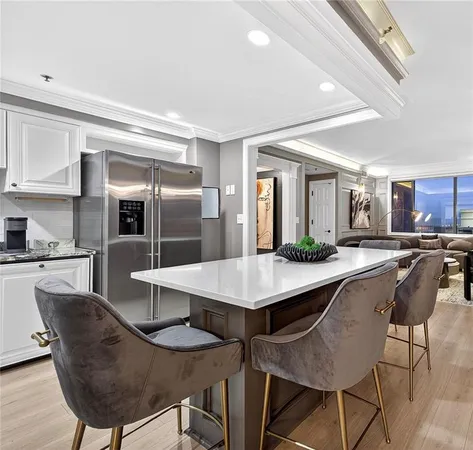 a kitchen with a dining table chairs and refrigerator
