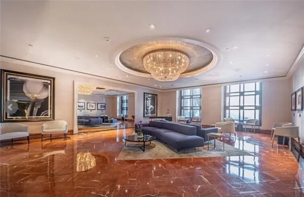 a living room with furniture a chandelier and large window