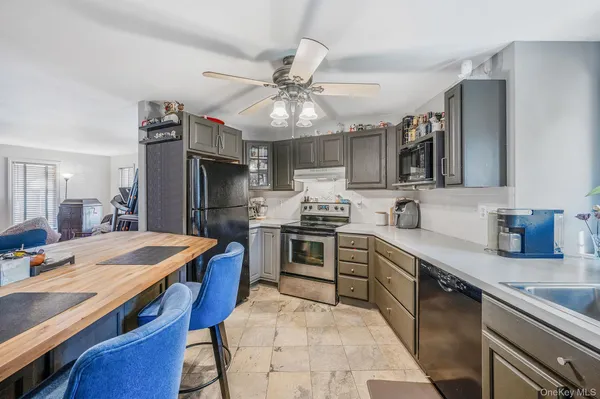 a open kitchen with stainless steel appliances kitchen island granite countertop a table chairs sink and cabinets