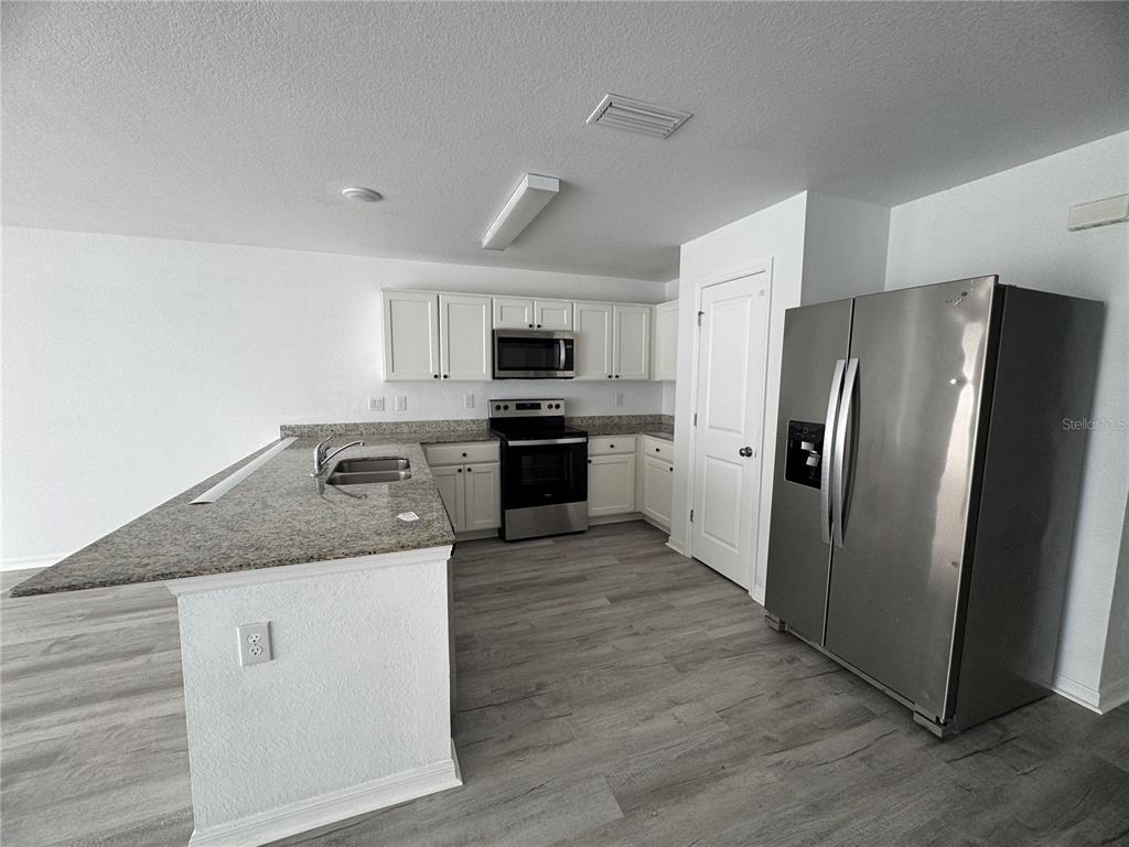 2173 Halblum Street North Port, FL 34288 - Photo 10 of 18 a kitchen with stainless steel appliances granite countertop a refrigerator stove and microwave