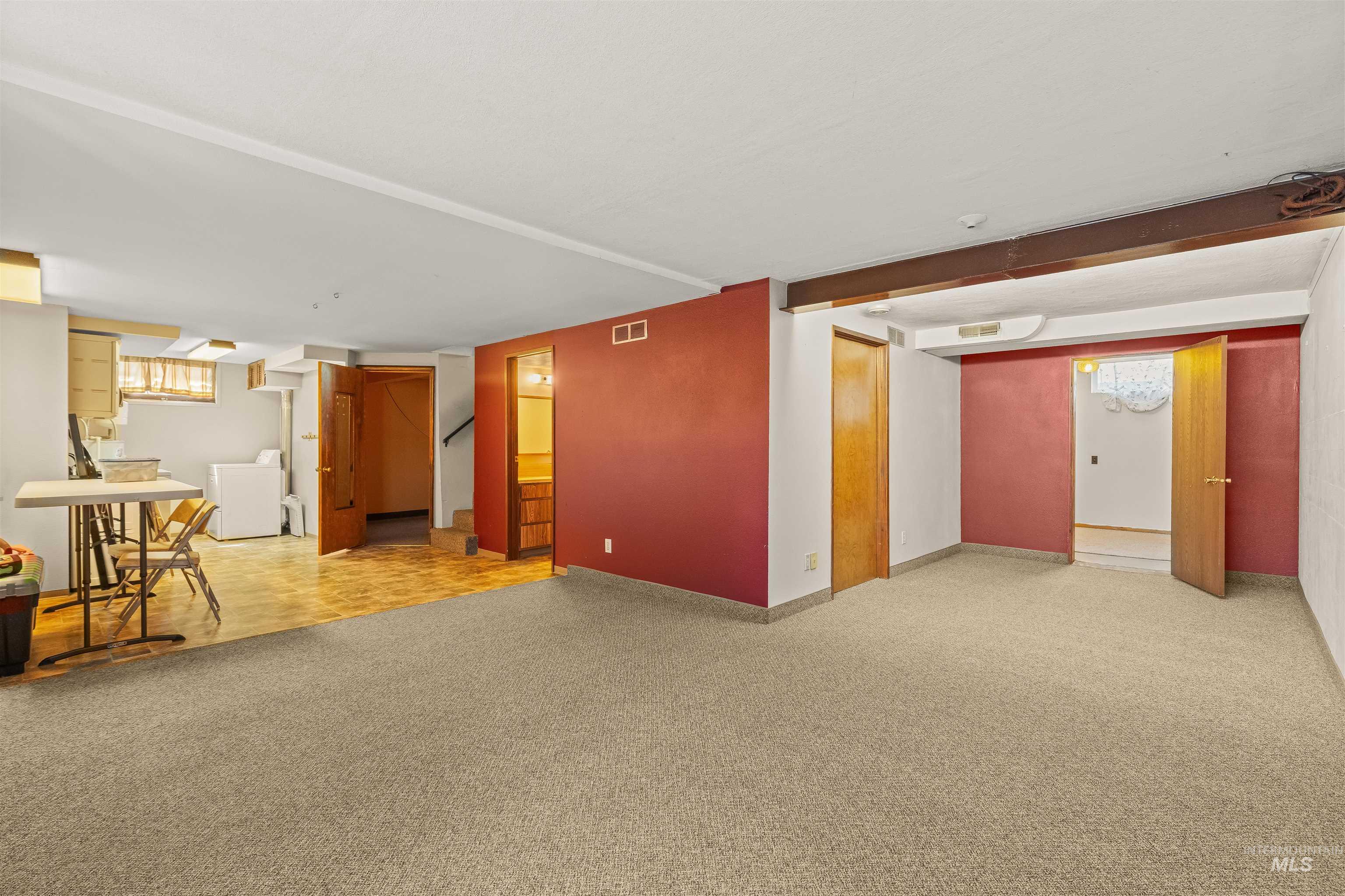 1663 9th Avenue Lewiston, ID 83501 - Photo 21 of 36 Carpeted recreation area featuring an exposed wood beam, a doorway, and a separate utility area with wood-finish flooring