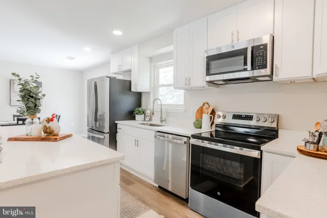 a kitchen with stainless steel appliances a stove microwave and refrigerator