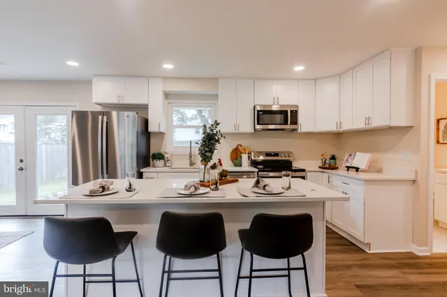 a kitchen with stainless steel appliances granite countertop a stove a sink a refrigerator and a refrigerator