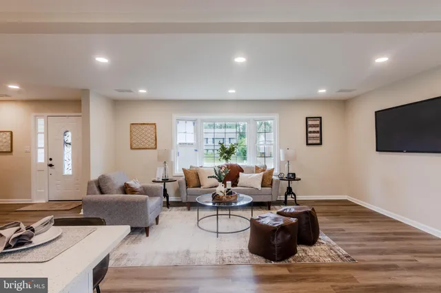 a living room with furniture wooden floor and a flat screen tv