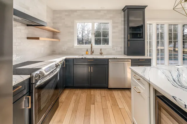 a kitchen with stainless steel appliances granite countertop a sink and a stove top oven