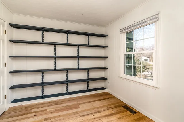 a view of a room with a window and wooden floor