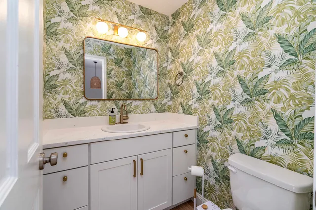 a bathroom with a sink and mirror with toilet