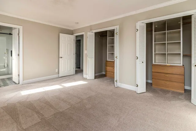 a view of an empty room with a cabinet and mirrors
