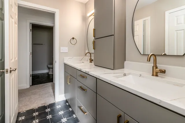 a bathroom with a double vanity sink and a mirror