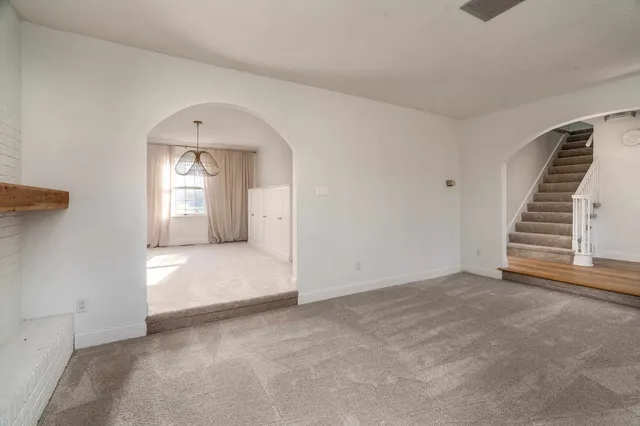 an empty room with a fireplace and windows