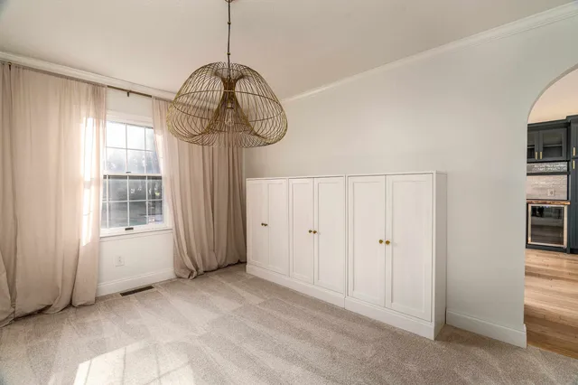 a view of empty room with window and chandelier
