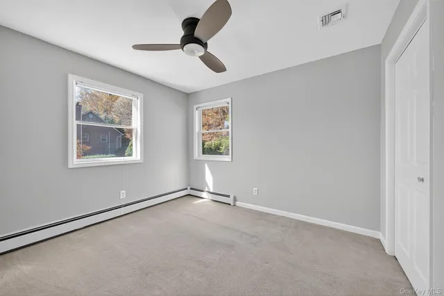 a view of empty room with closet and cabinet