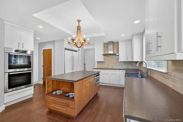 a kitchen with stainless steel appliances granite countertop a stove a sink and a refrigerator