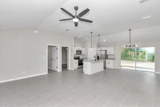 a view of an empty room and kitchen view