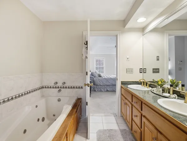 a spacious bathroom with a tub sink and mirror