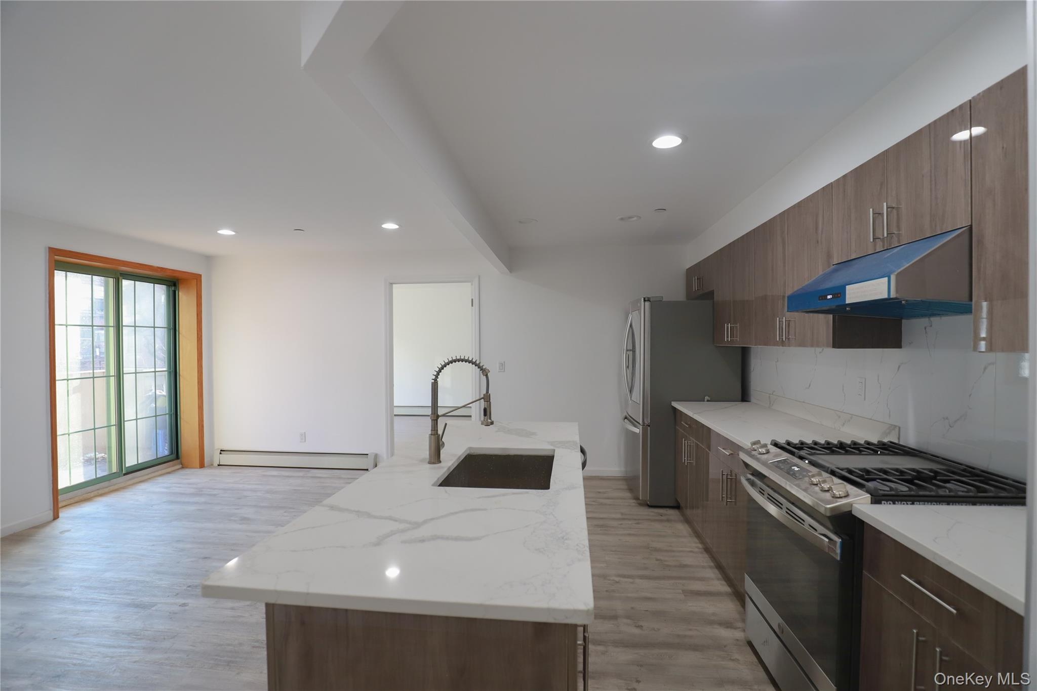 134-43 Maple Avenue, Unit 2A Queens, NY 11355 - Photo 14 of 15 a kitchen with a sink stainless steel appliances and cabinets
