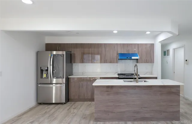 a kitchen with kitchen island a counter top space cabinets and stainless steel appliances