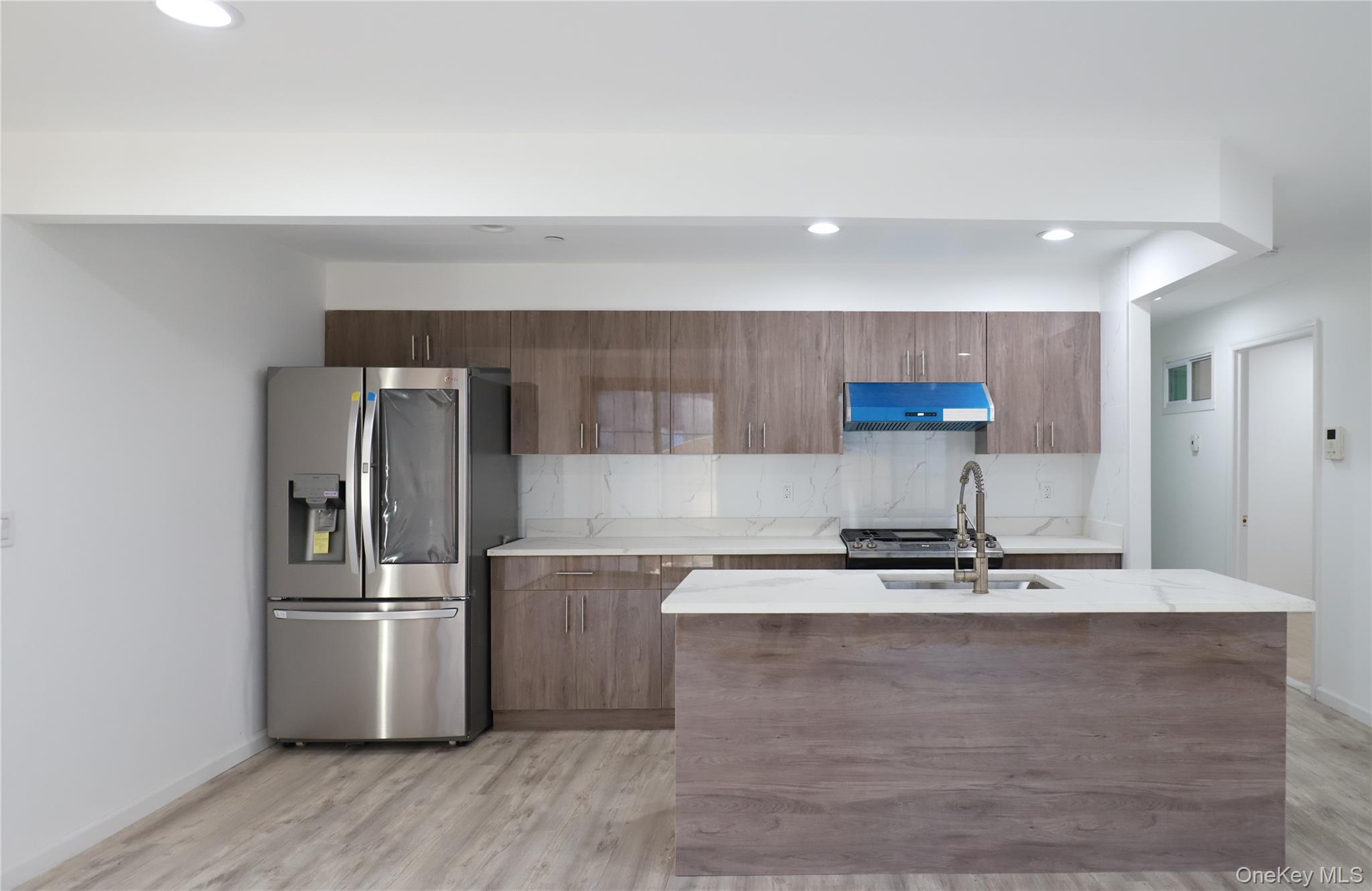 134-43 Maple Avenue, Unit 2A Queens, NY 11355 - Photo 2 of 15 a kitchen with kitchen island a counter top space cabinets and stainless steel appliances