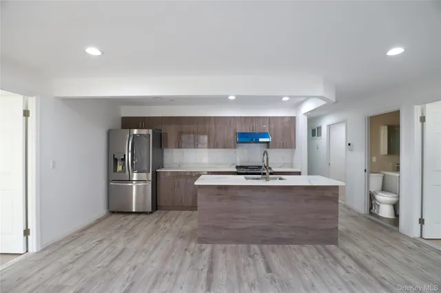 a kitchen with stainless steel appliances a stove and wooden floor