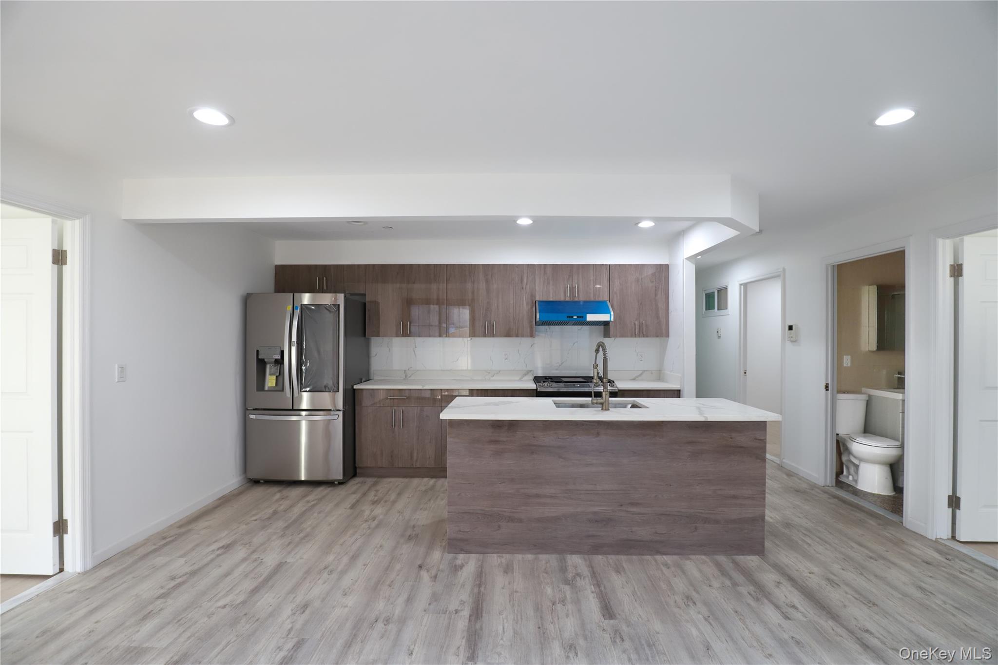 134-43 Maple Avenue, Unit 2A Queens, NY 11355 - Photo 3 of 15 a kitchen with stainless steel appliances a stove and wooden floor