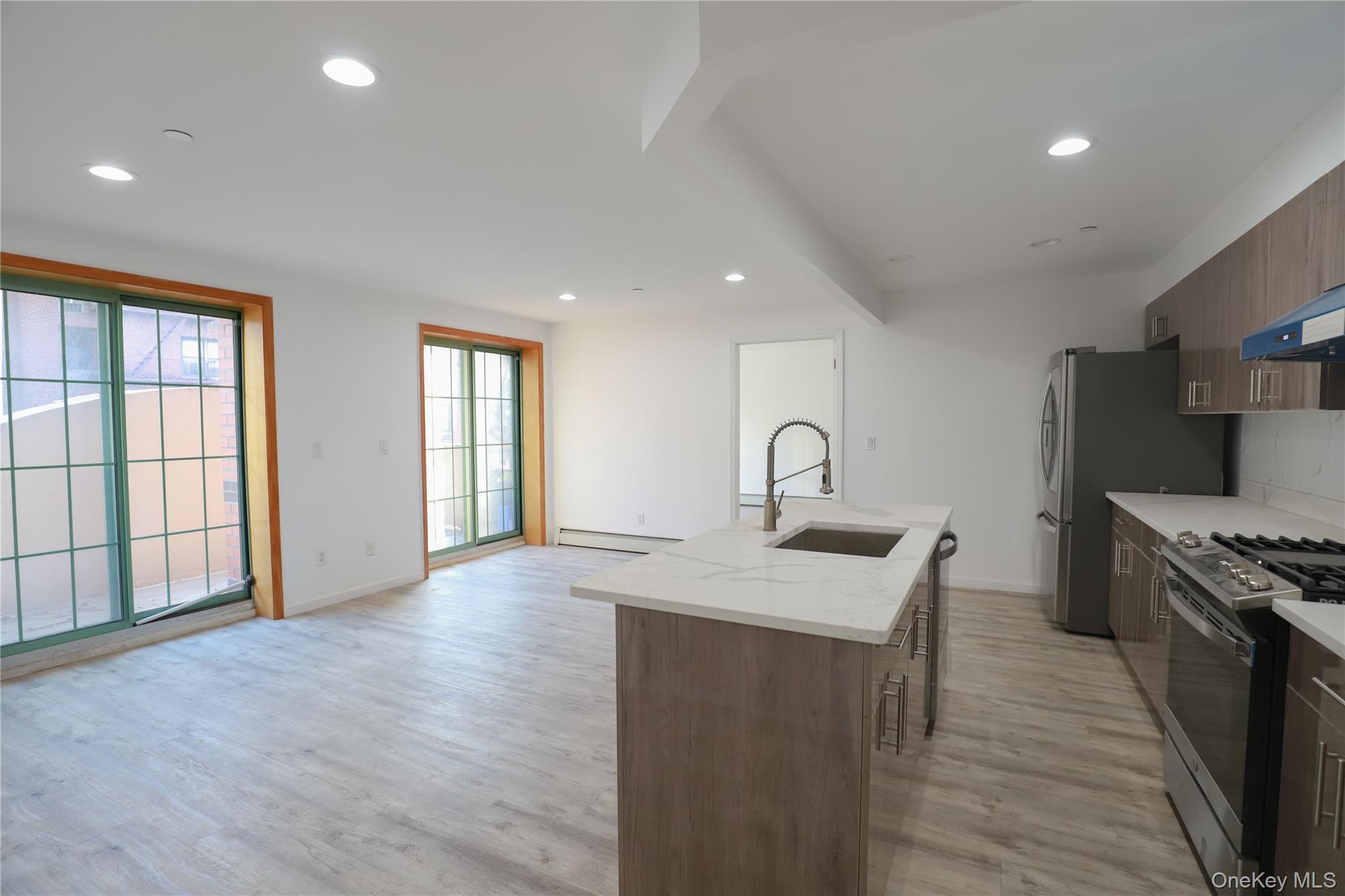 134-43 Maple Avenue, Unit 2A Queens, NY 11355 - Photo 4 of 15 a kitchen with stainless steel appliances granite countertop a sink a stove and a wooden floors