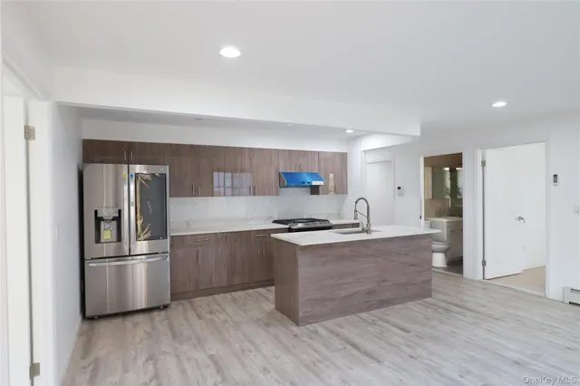 a kitchen with stainless steel appliances granite countertop a stove a refrigerator and a sink