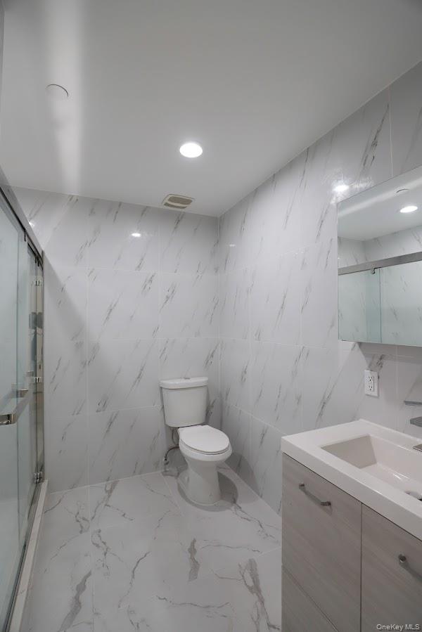 134-43 Maple Avenue, Unit 2A Queens, NY 11355 - Photo 9 of 15 a bathroom with a sink a toilet and a shower