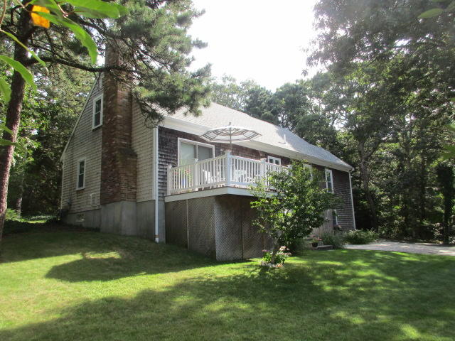 4 Stage Coach Road Harwich, MA 02645 - Photo 28 of 34 a backyard of a house with potted plants and large tree